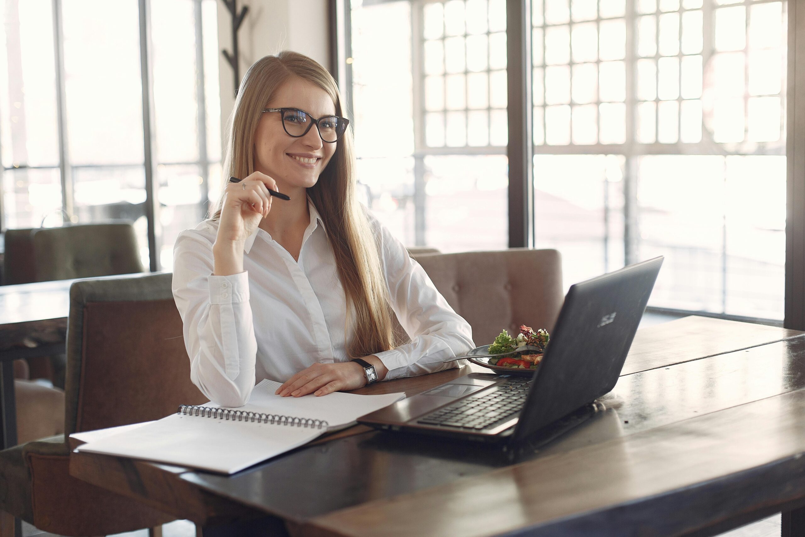 A skilled woman planning her marketing career path with a notebook and laptop.