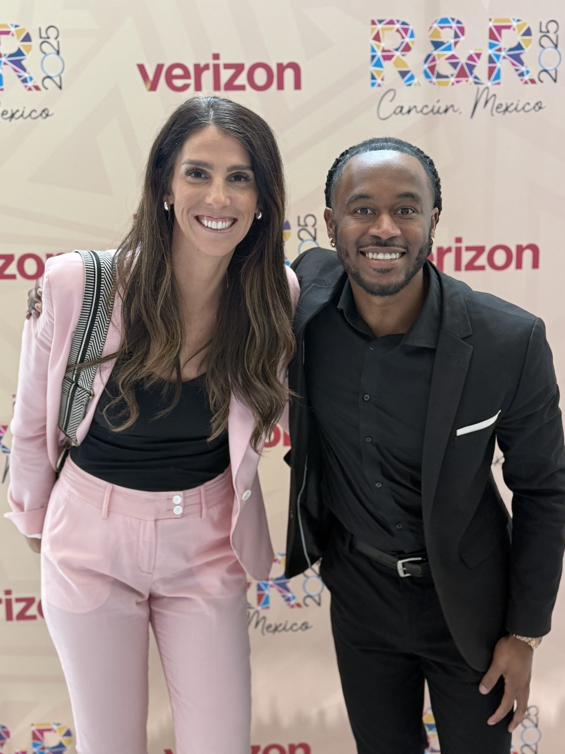 Two representatives standing together before a Verizon community event backdrop