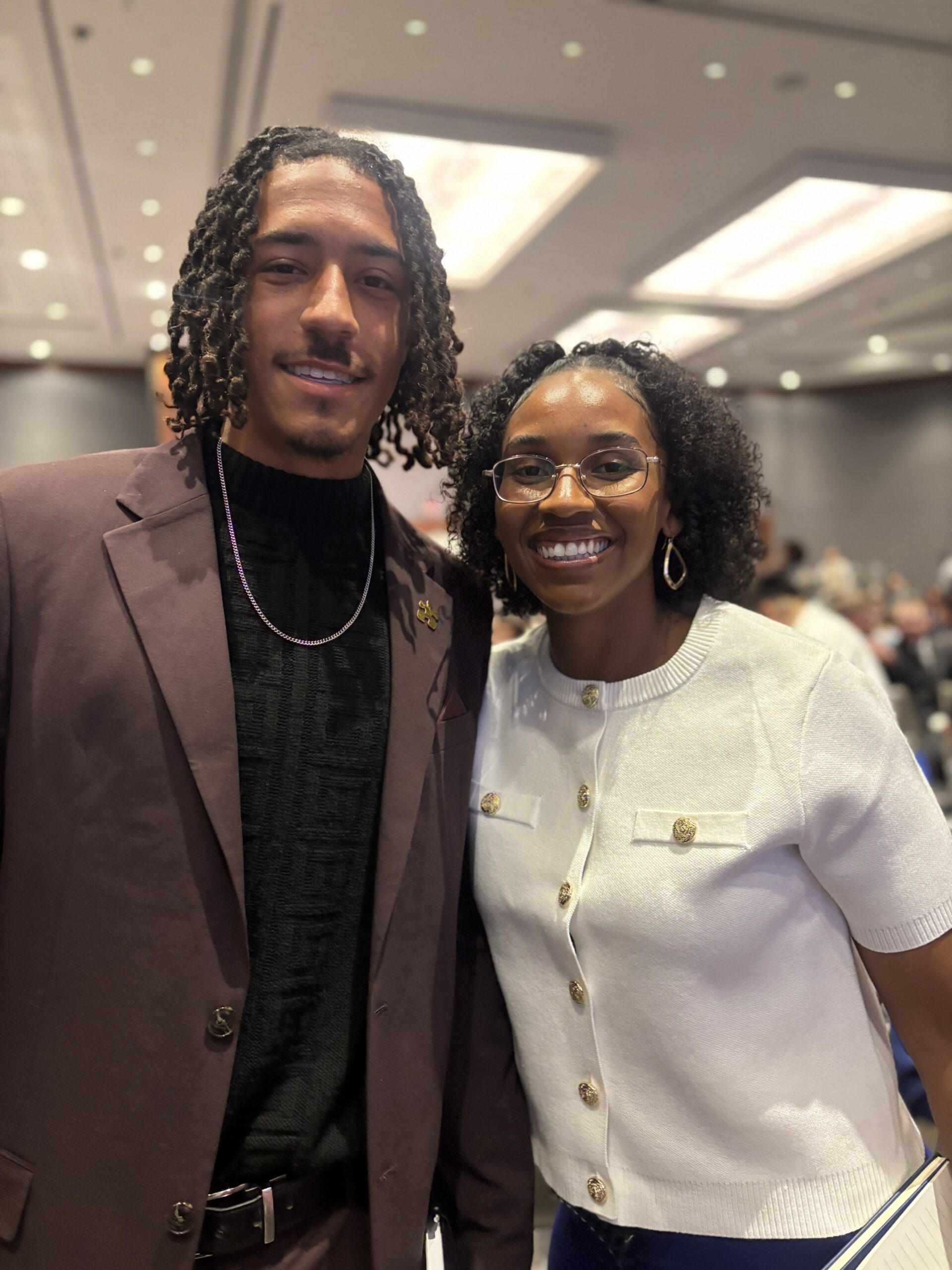 Two colleagues smiling together at a professional event